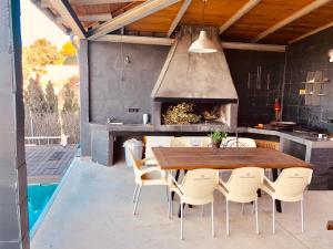 an outdoor kitchen with a wooden table and chairs at VILLA LA DUQUESA 