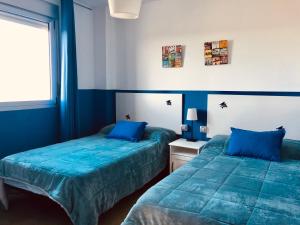 2 camas en una habitación con paredes azules en VILLA LA DUQUESA, 