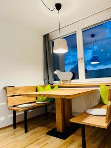 a wooden table and bench in a room with a window at Wellnessapartment Alpenland Top 22 in Seefeld in Tirol