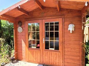 Cabaña de madera pequeña con puerta en Tan y coed's Rosemary Cabin, en Conwy