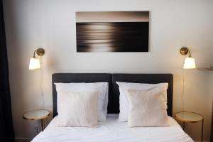 a bedroom with a bed with white pillows and two lamps at Villa Bérylune in Ostend