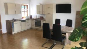 eine Küche mit Tisch und Stühlen in einem Zimmer in der Unterkunft Ferienwohnung Jung in Hohenburg