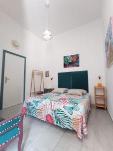 una camera da letto con un letto con un piumone colorato di Green House ad Avola