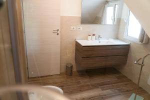 een badkamer met een wastafel, een spiegel en een douche bij Alessandra's apartment in Sassari