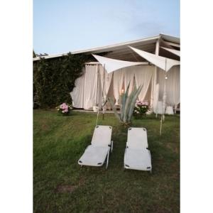 2 Liegestühle und Sonnenschirme vor einem Zelt in der Unterkunft Alos 2 in Amolianí