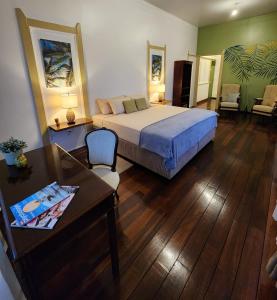 um quarto com uma cama e uma mesa e uma mesa sidx sidx sidx em Queen Maxima by Prins Hendrik Suites em Paramaribo