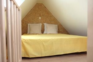 - une chambre mansardée avec un lit jaune dans l'établissement Villa Bérylune, à Ostende