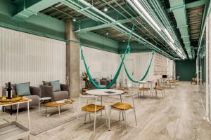 a room with tables and chairs and green ceilings at UTOPIC Polanco by ULIV in Mexico City