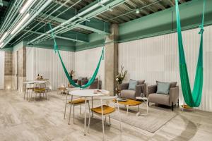 Una habitación con mesas y sillas y cuerdas verdes. en UTOPIC Polanco by ULIV, en Ciudad de México