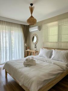 una camera da letto con un grande letto con due asciugamani di Ella Alaçatı Otel a Ildir