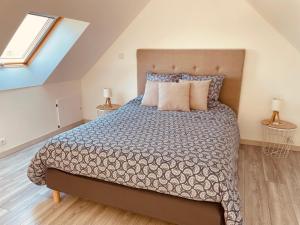 una camera da letto con un grande letto con cuscini di Sur le chemin de la plage a Cherbourg en Cotentin