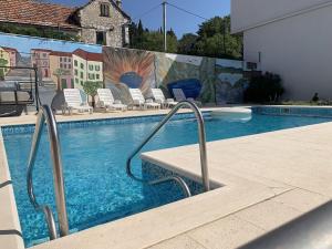 een zwembad met stoelen en een muurschildering bij Zimmer mit Bad Imotski in Imotski