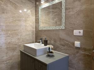 een badkamer met een witte wastafel en een spiegel bij Zimmer mit Bad Imotski in Imotski