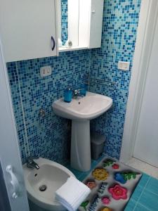 a small bathroom with a sink and a toilet at Eva Casa Vacanza in Felline +16 photos