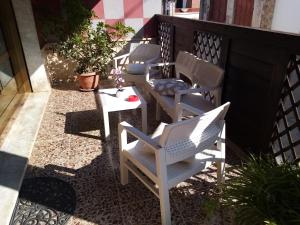 a row of chairs and a table on a patio at Eva Casa Vacanza in Felline