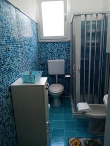 ein blau gefliestes Bad mit WC und Waschbecken in der Unterkunft Eva Casa Vacanza in Felline