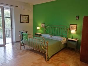 MontesarchioにあるVilla Montemmaの緑のベッドルーム(ベッド1台、ランプ2つ付)