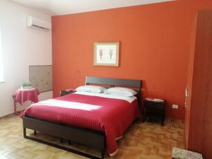een slaapkamer met een bed met een oranje muur bij Villa Montemma in Montesarchio