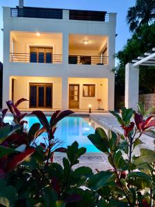 a house with a swimming pool in front of it at Aggelos and Thisbe Chania Suburbs Sea View Guest House in Chania Town