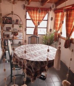 a dining room with a table and chairs and a window at Casa con vista a la salida del sol in La Cumbre