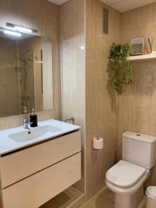 a bathroom with a sink and a toilet and a mirror at Seaview in Villajoyosa