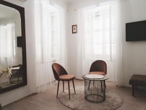 Una habitación con dos sillas, una mesa y un espejo. en Old city center, en Rijeka