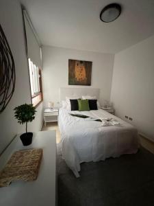 a bedroom with a white bed and a potted plant at Muy cómodo y cerca de la playa Supreme Puertito 7 in Puertito de Güímar