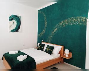 Un dormitorio con una cama con una pared verde. en Old city center, en Rijeka