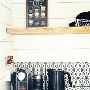 a shelf above a kitchen counter with black appliances at The Wee Stay - Rural Guest Suite with outdoors Kitchen and covered Livingroom area in Crook of Devon