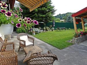 a patio with chairs and a yard with flowers at Private House with Garden 