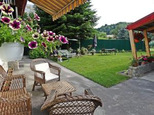 een patio met stoelen en een tuin met bloemen bij Private House with Garden 