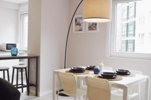 拉科魯尼亞的住宿－JOMAR Apartamento en Coruña，白色的用餐室配有白色的桌椅