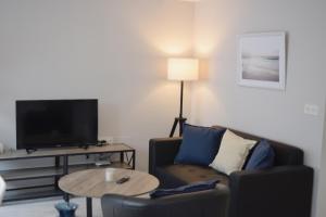 a living room with a couch and a table with a tv at JOMAR Apartamento en Coruña in A Coruña