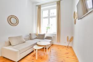 a white living room with a white couch and a table at Sopot City Centre, Apartment 774 in Sopot