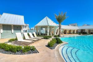 a swimming pool with lounge chairs and a house at The Spanish Dagger in Port Aransas