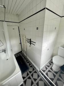 a bathroom with a toilet and a tub and a sink at Spacious 4 Bed Property - Sleeps 8 in Gateshead in Felling