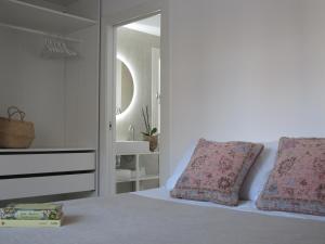 een slaapkamer met een bed met 2 kussens en een spiegel bij La Llisa in Santa Pola