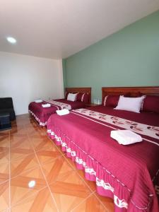 two beds in a room with red sheets and white napkins at Hotel John & Rose in Comitán de Domínguez