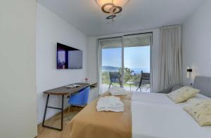 a bedroom with two beds and a desk and a window at Villa Diamante del Garda & Spa in Toscolano Maderno +114 photos