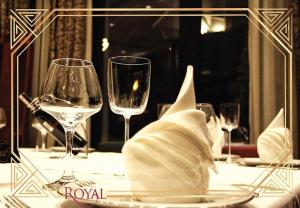 una mesa con dos copas de vino y una servilleta en Hotel Royal, en Pristina