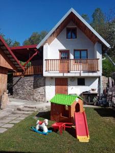 a house with a play set in the yard at Chata u poľovníka 