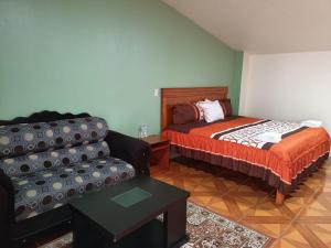 ein Wohnzimmer mit einem Bett und einem Sofa in der Unterkunft Hotel John & Rose in Comitán de Domínguez