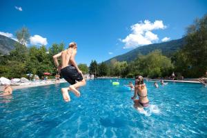 a man and a girl jumping into a swimming pool at home B29 in Landeck