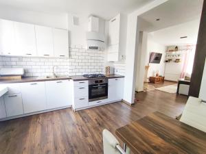 una cucina con armadietti bianchi e pavimenti in legno di Apartament ,,STORCZYK'' a Giżycko