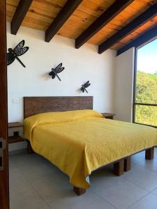 - une chambre avec un lit avec 2 papillons sur le mur dans l'établissement Cabañas Rinconada Tapalpa, à San Antonio