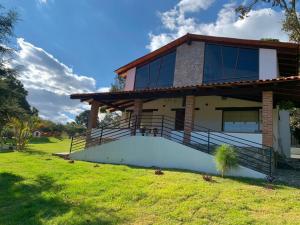 une maison avec de grandes fenêtres et une pelouse dans l'établissement Cabañas Rinconada Tapalpa, à San Antonio