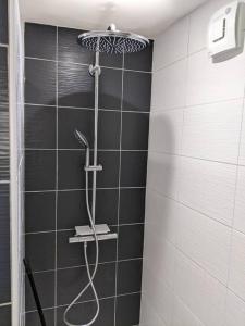 La salle de bains est pourvue d'une douche et de carrelage noir et blanc. dans l'établissement À l'ombre de l'abbatiale, 90 m² rénovés 3 chambres, à Aurillac