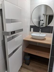 La salle de bains est pourvue d'un lavabo et d'un miroir. dans l'établissement À l'ombre de l'abbatiale, 90 m² rénovés 3 chambres, à Aurillac