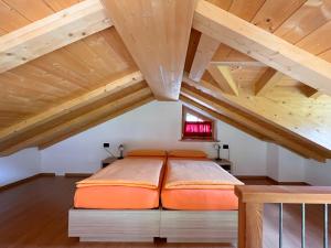 a bedroom with an orange bed in a attic at Chalet I Clus in Livigno
