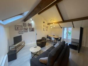 a living room with a couch and a table at Le Dortoir Daubigny in Auvers-sur-Oise